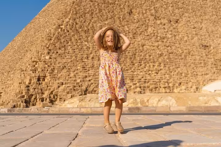 Child posing near the Great Pyramid of Giza on family-friendly Cairo tour to pyramids, Sphinx and GEM