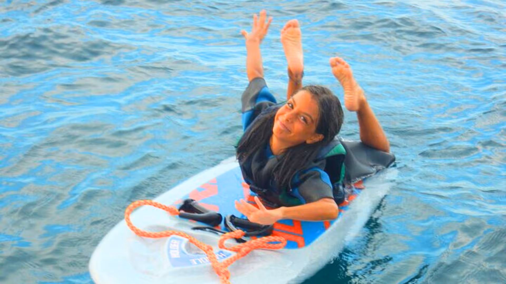 Child having fun on a kneeboard in Golfo degli Angeli, Cagliari's beautiful blue waters.