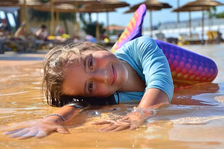 Joyful child in mermaid costume enjoying the water at a private photoshoot in Hersonissos.