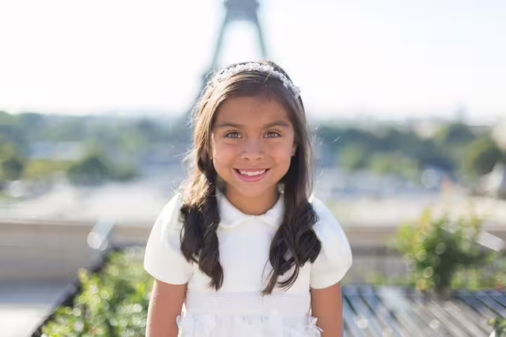 Smiling child portrait with Eiffel Tower backdrop on a private Paris travel photographer tour session