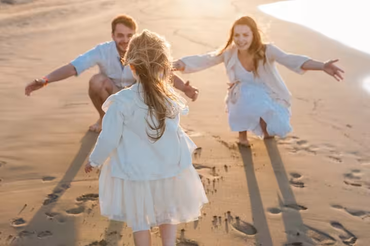 Child running towards parents on Heraklion beach, showcasing a heartwarming family photoshoot opportunity.