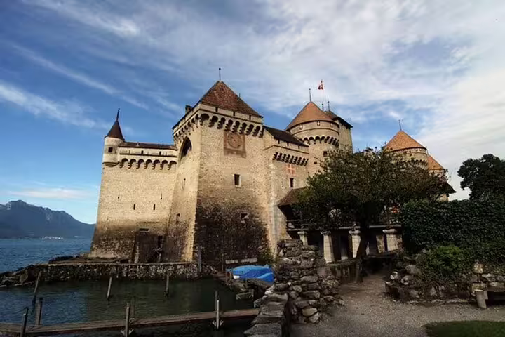 Chillon Castle stone towers and turrets on the shores of Lake Geneva under blue sky