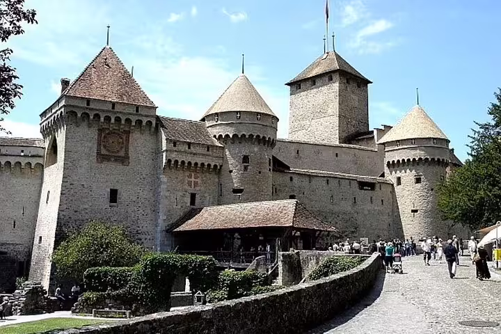 Chillon Castle medieval stone towers and entrance with tourists on a sunny day in Montreux, Switzerland