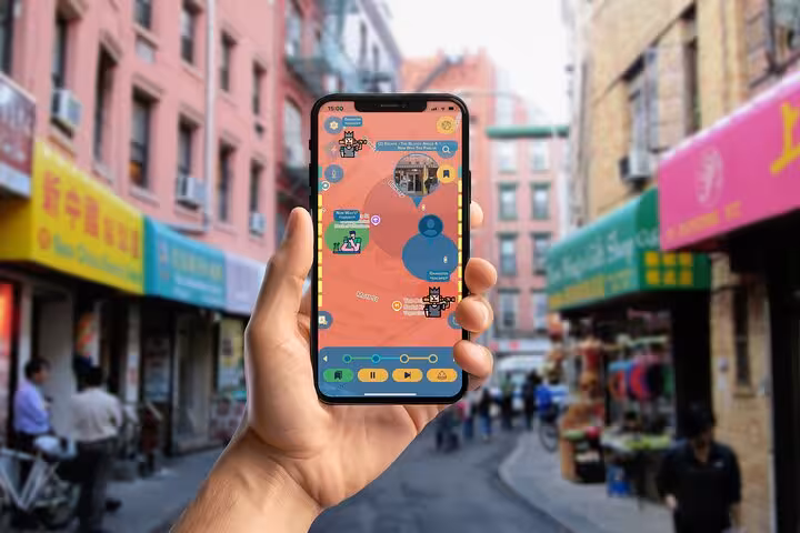Self-guided Chinatown NYC walking tour app displayed on phone amid bustling market street with colorful shops