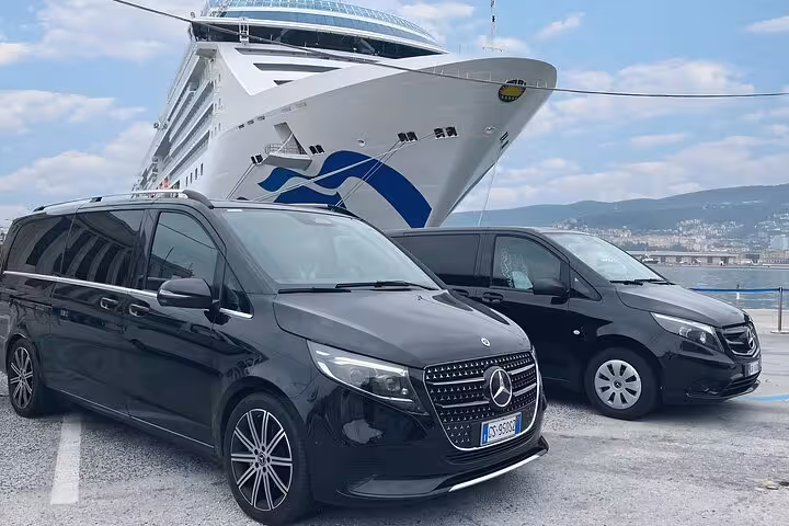 Two sleek black Mercedes vans ready for Chioggia Port to Venice private water taxi transfers, cruise ship in view.