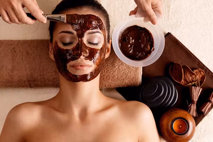 Chocolate facial mask application at Sharm El Sheikh Chocolate Magic Bath Spa Experience with spa candles