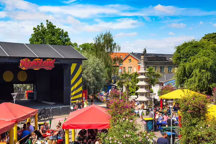 Nemoland outdoor venue in Christiania Copenhagen with colorful umbrellas, pagoda, and crowds on a sunny day
