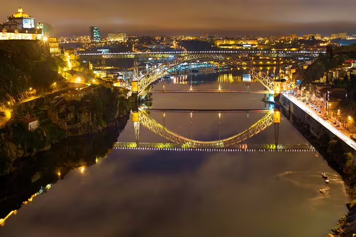 Scenic night panorama of a brightly lit bridge reflecting on the river, highlighting the Christmas cruise route.