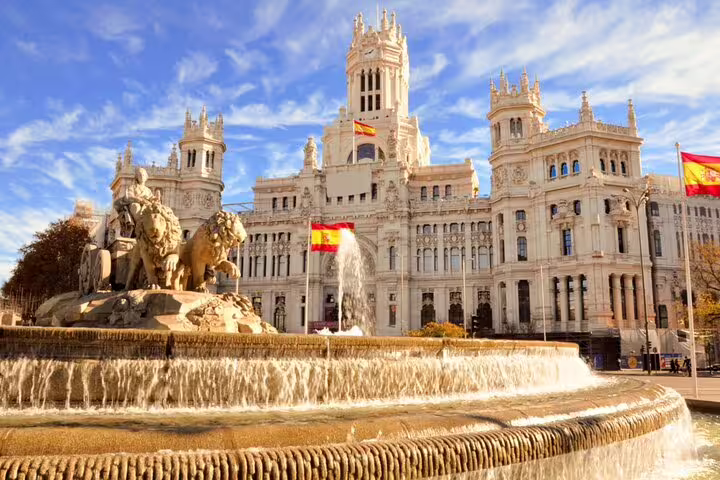 Cibeles Fountain and Palacio de Cibeles in Madrid, Spain with Spanish flags