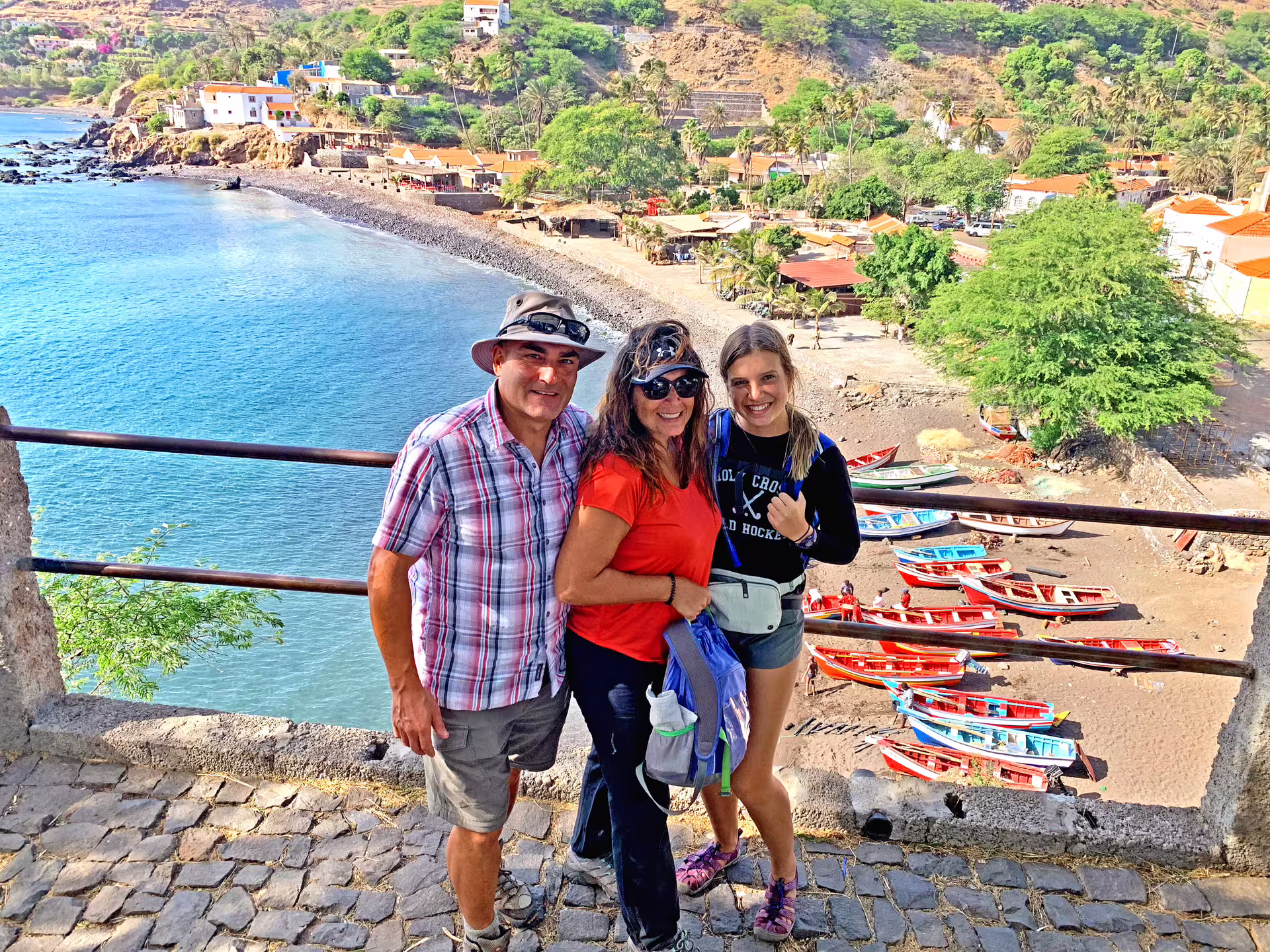 Tourists enjoying the scenic coastal view of Cidade Velha with colorful boats and charming architecture.