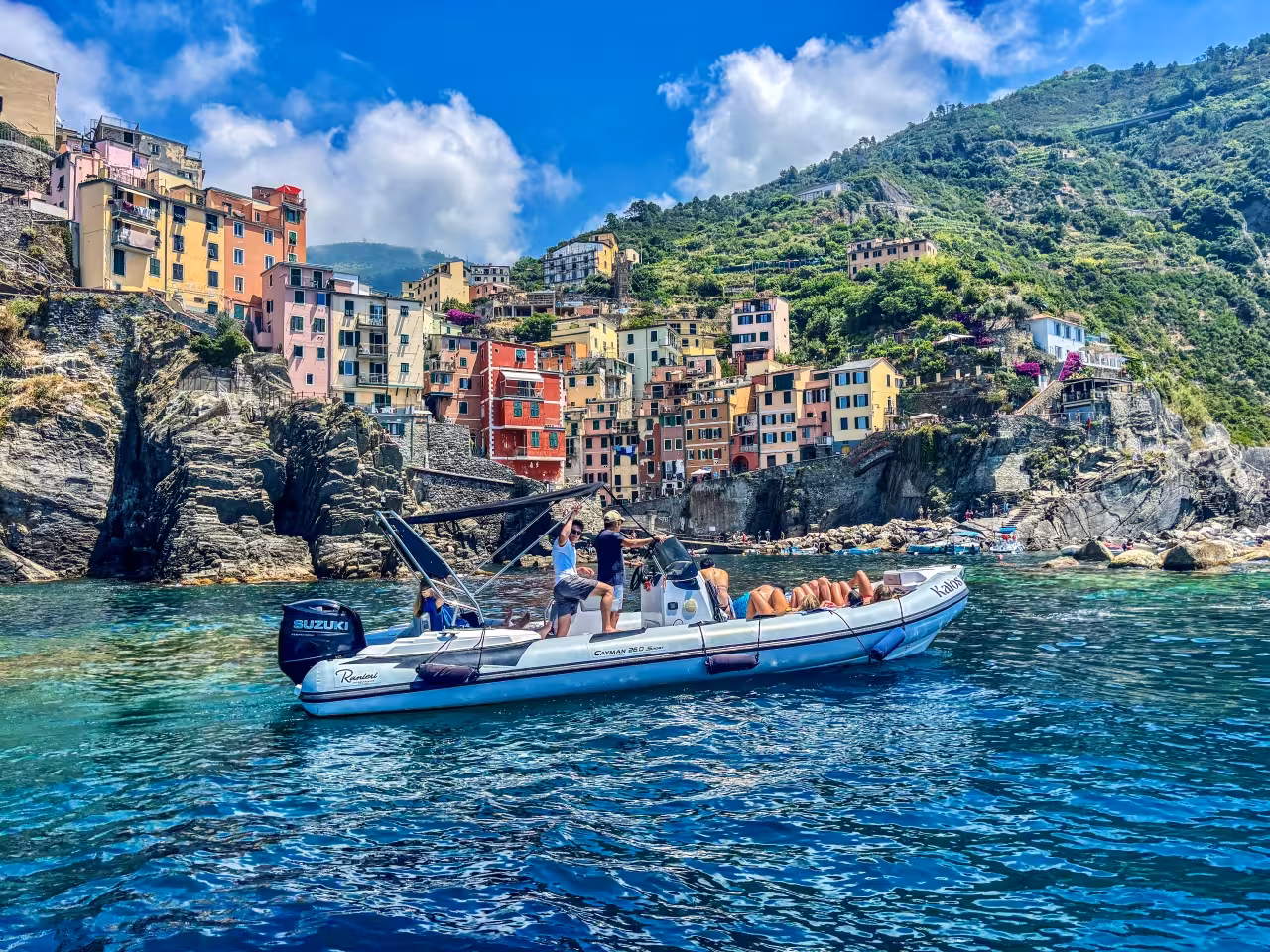 Cinque Terre boat tour from La Spezia passing colorful Riomaggiore cliffs on a sunny Ligurian day