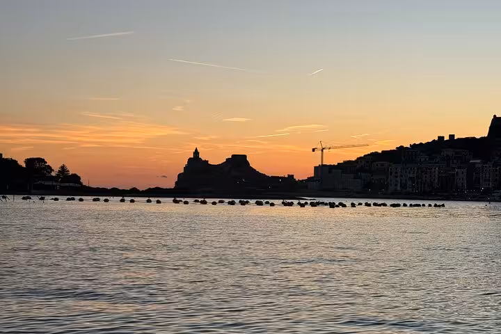 Breathtaking sunset view over the serene waters of Cinque Terre with silhouetted coastal landmarks.