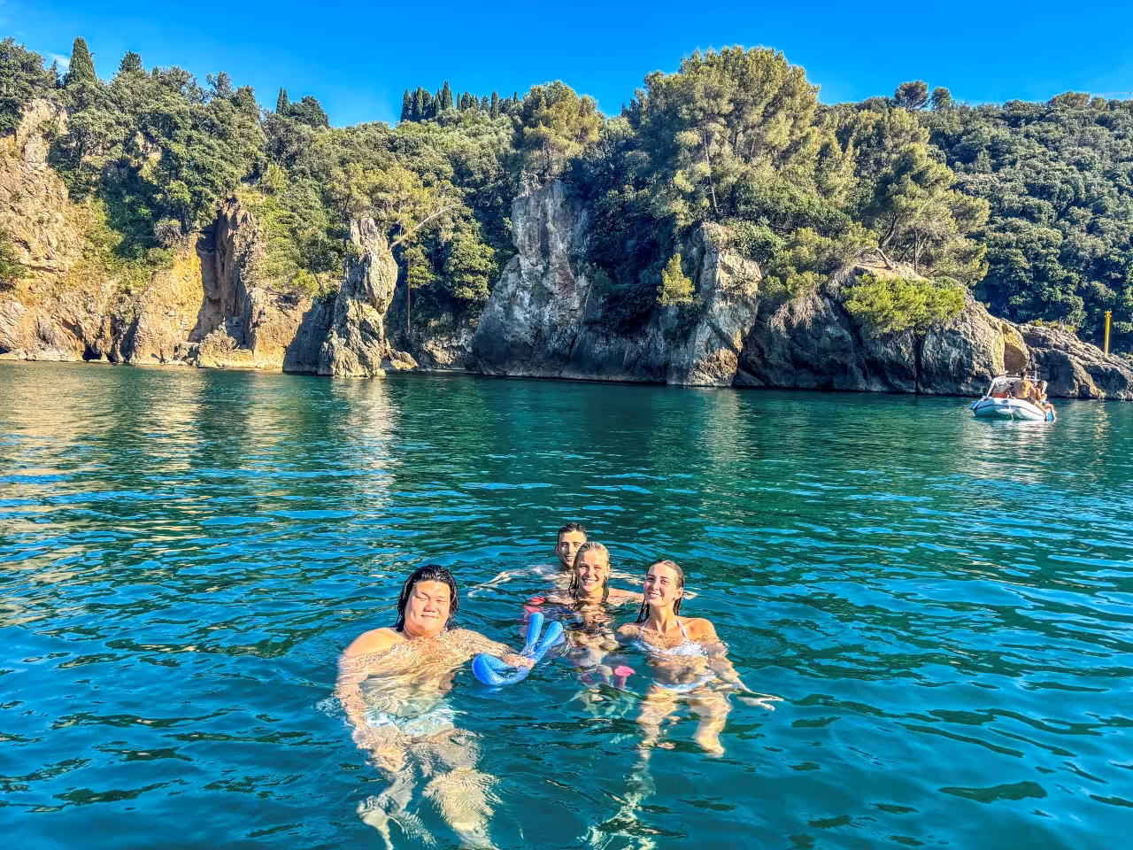 Guests swimming in a turquoise cove on a Cinque Terre full-day boat tour from La Spezia, Ligurian cliffs