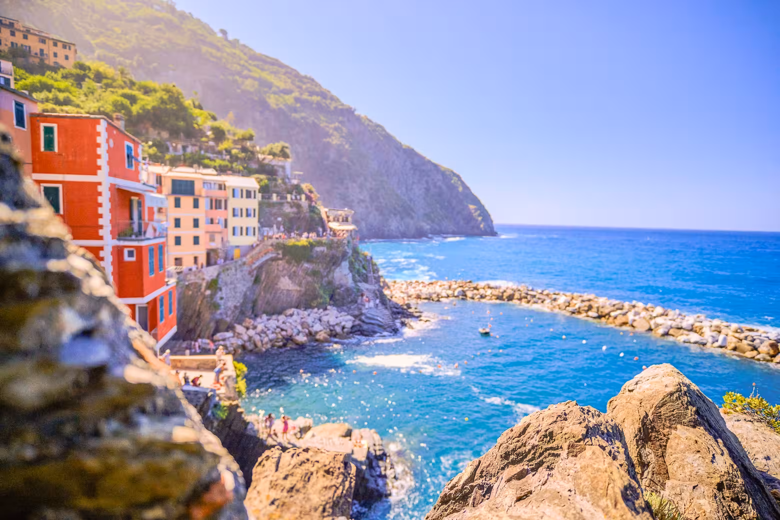 Breathtaking view of Cinque Terre's cliffside homes and azure waters on a sunny day tour.