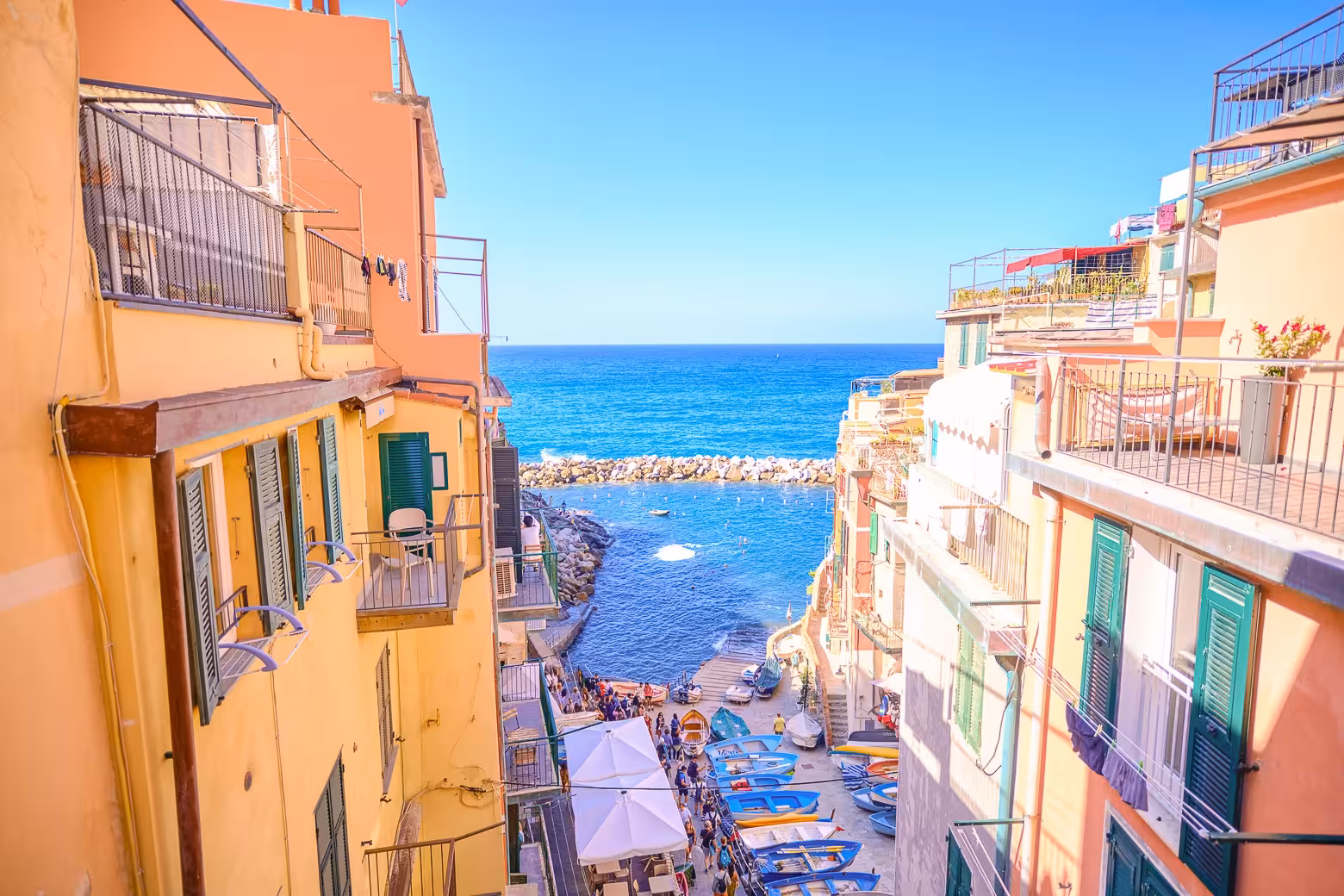 Colorful coastal village with boats and vibrant buildings overlooking the blue sea in Cinque Terre.