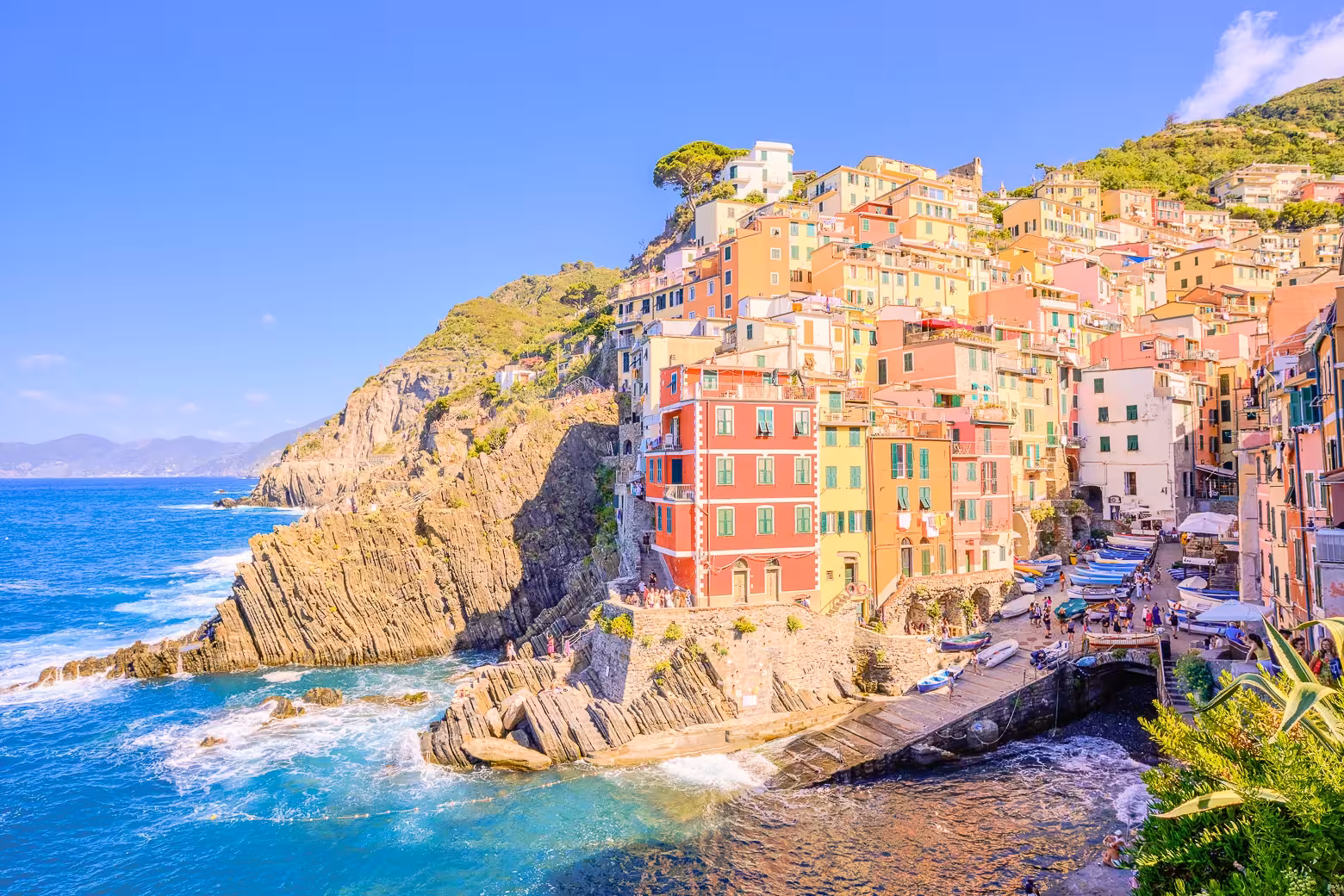 Colorful cliffside houses of Riomaggiore in Cinque Terre bathed in sunlight.