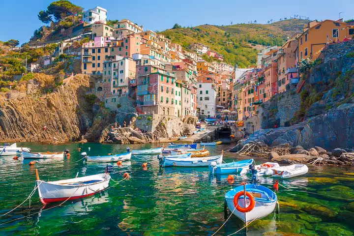 Colorful boats and vibrant cliffside houses in Riomaggiore, a highlight of the Cinque Terre private tour from Florence.