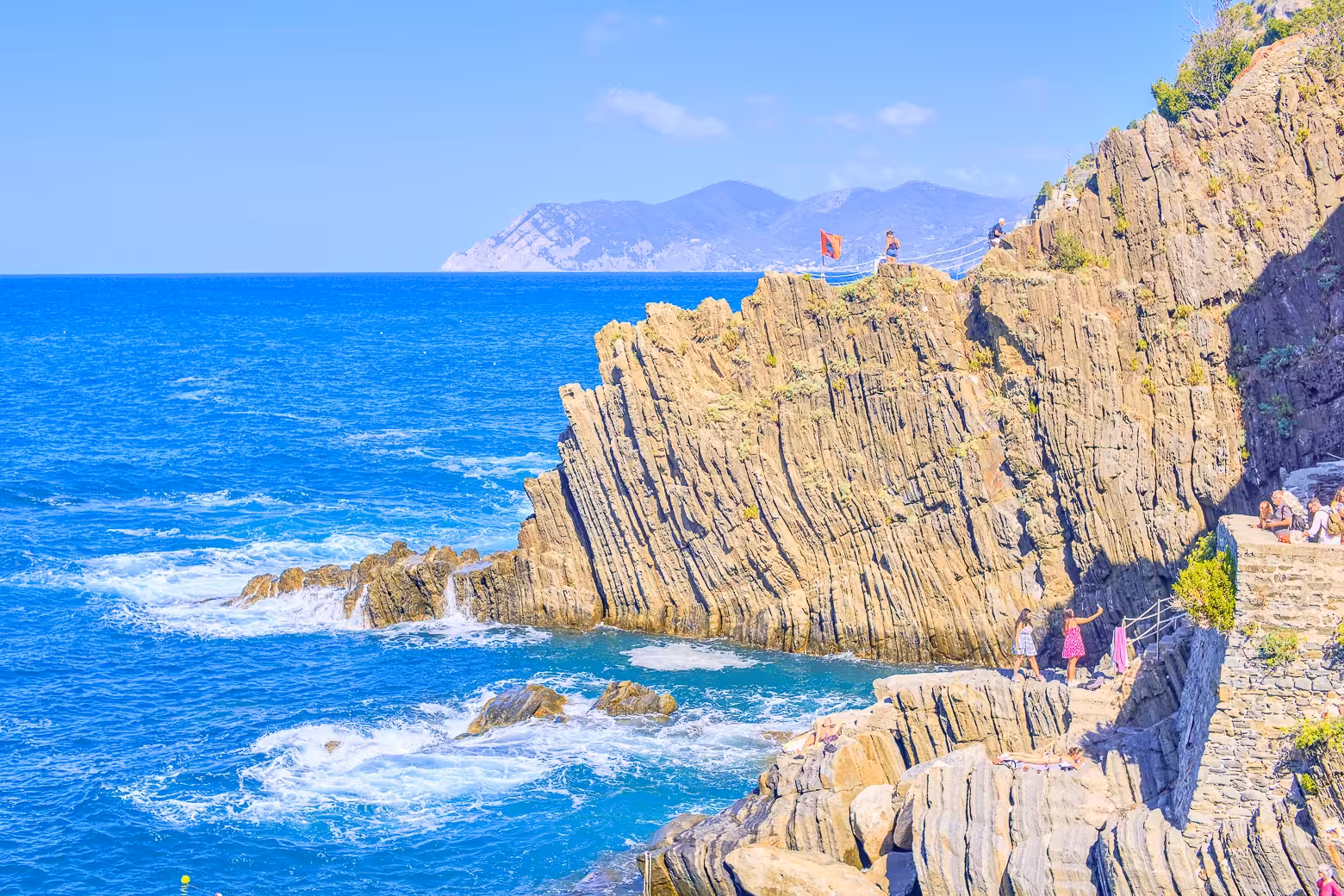 Dramatic rocky cliffs overlooking the vibrant blue sea in Cinque Terre, perfect for hiking and sightseeing.