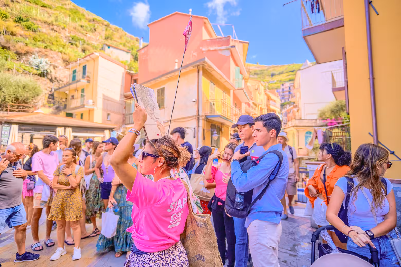 Tour guide leading a vibrant group through colorful streets of Cinque Terre, capturing the essence of local culture.