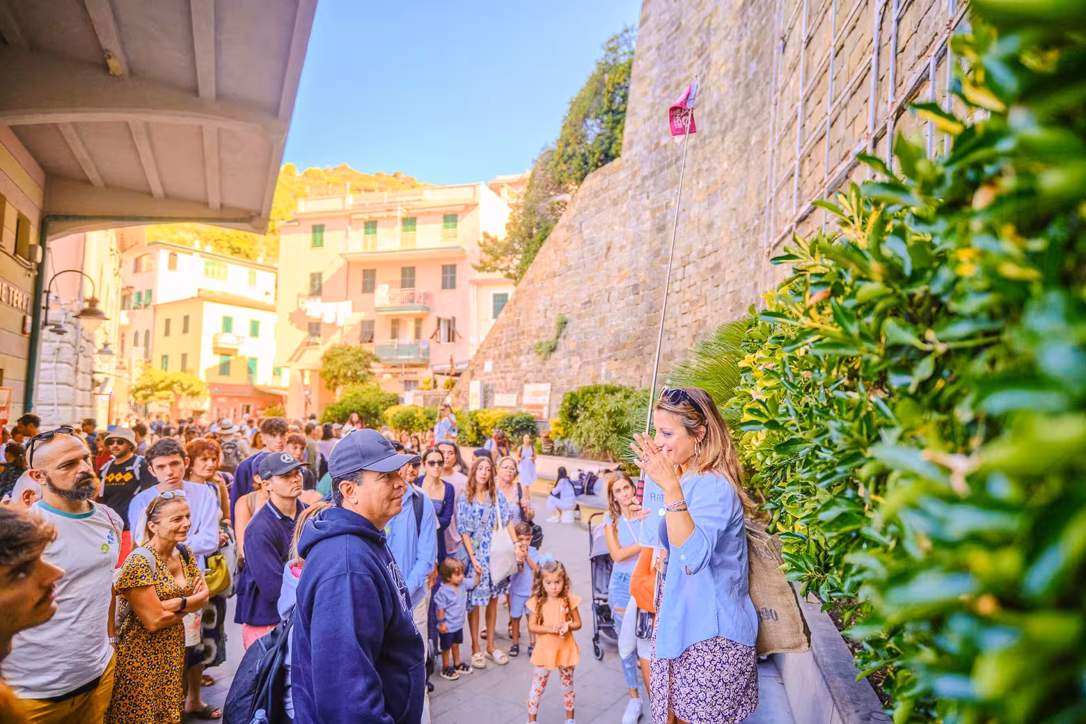 Guide engaging with tourists in lively Cinque Terre village during full-day tour from Florence.
