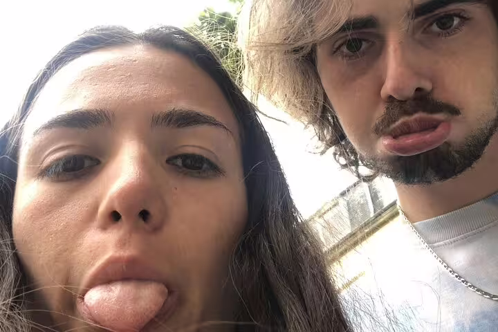 Two young people making funny faces during a city walking tour adventure
