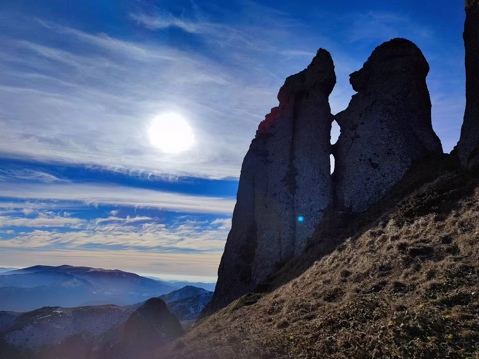 Dramatic rock pinnacles at Ciucas Peak 1954m against blue sky, Romanian Carpathian mountains in background
