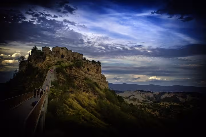 Breathtaking view of Civita di Bagnoregio at sunset, accessible by bridge, included in full-day private tour with wine tasting.