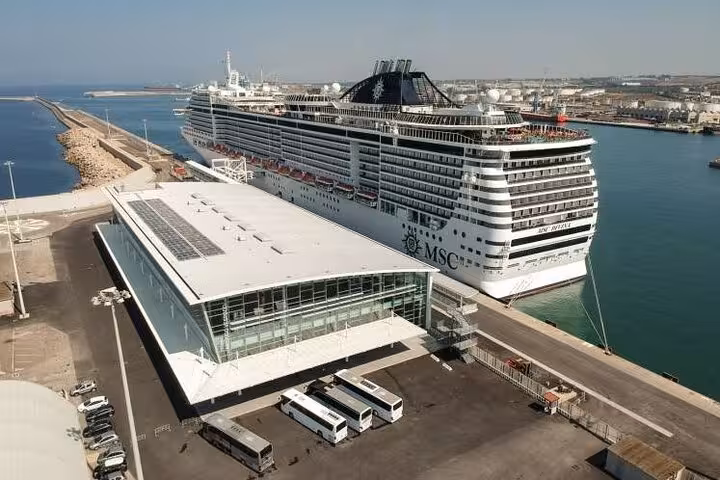 Cruise ship docked at Civitavecchia Port, gateway for private day trips to Rome, with modern vehicles ready for transfer.