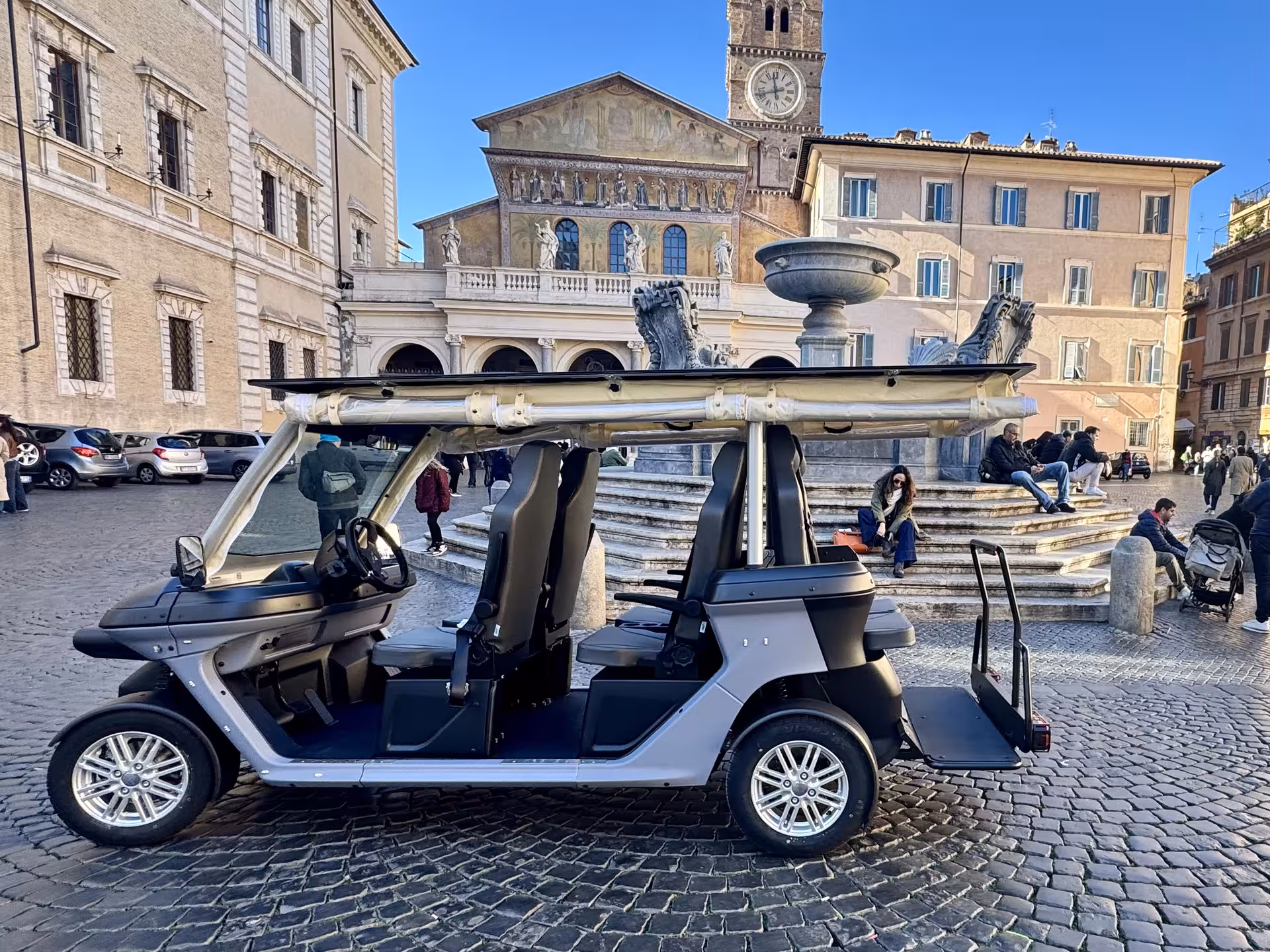 Electric golf cart parked in Piazza di Santa Maria in Trastevere on a Civitavecchia to Rome private sightseeing tour
