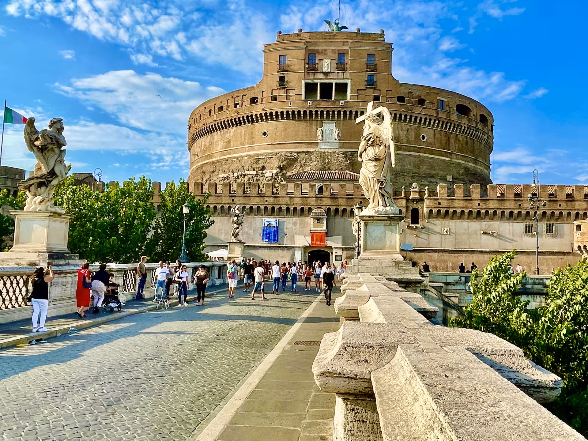 Tourists walking across Ponte Sant’Angelo toward Castel Sant’Angelo in Rome on a shore excursion from Civitavecchia