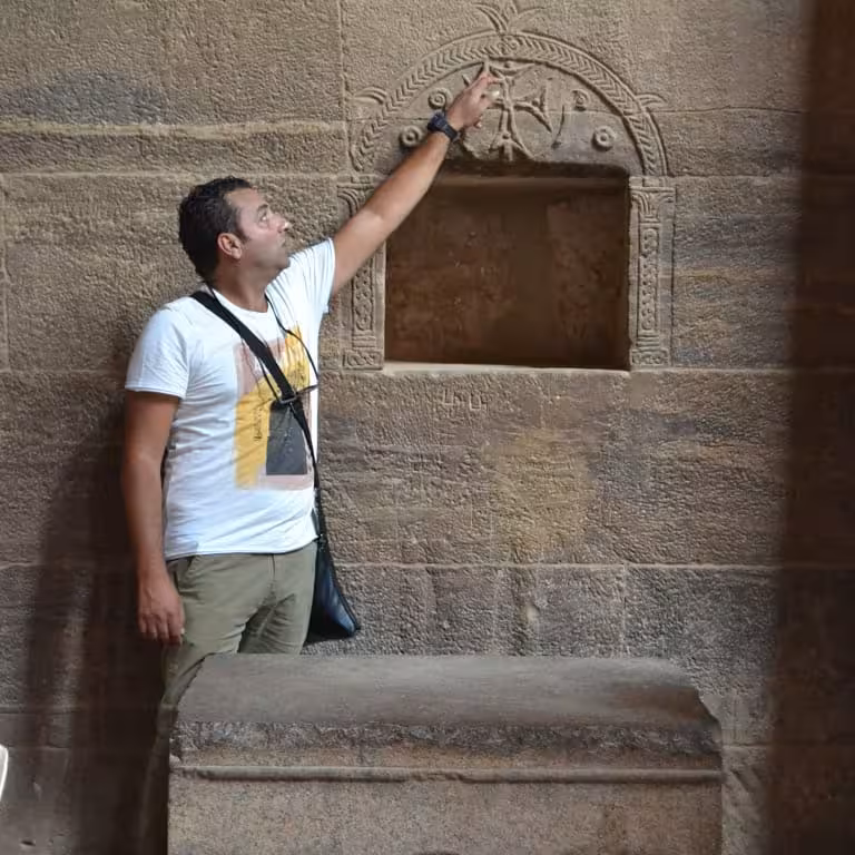 Local guide pointing to ancient temple carvings on Cleopatra’s Egypt tour, with Cairo, Alexandria and luxury Nile cruise