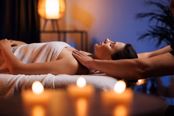 Woman enjoying relaxing full-body massage with candlelit ambiance at Cleopatra’s Luxury Spa Sharm El Sheikh