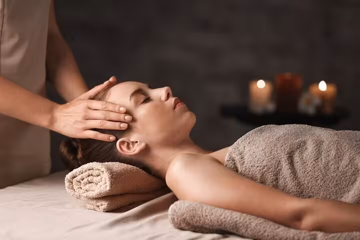 Therapist giving calming head massage at Hurghada Cleopatra Deluxe Spa, luxury sauna and jacuzzi package