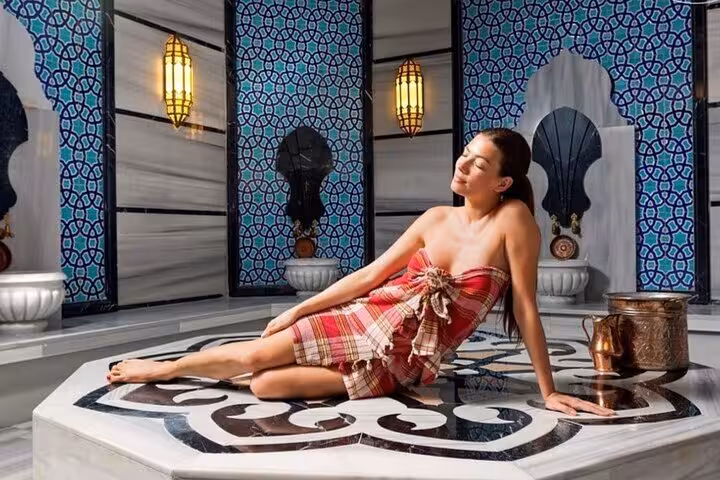 Woman relaxing in Turkish hammam at Hurghada Cleopatra Deluxe Spa, marble steam bath with sauna and jacuzzi
