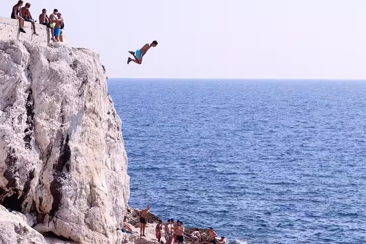Cliff jumper over Mediterranean near Marseille, action shot practice during photographic travel workshop excursion