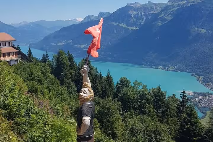Scenic mountain view with a joyful statue and vibrant lake, highlighting landscapes on the CLOY private tour.