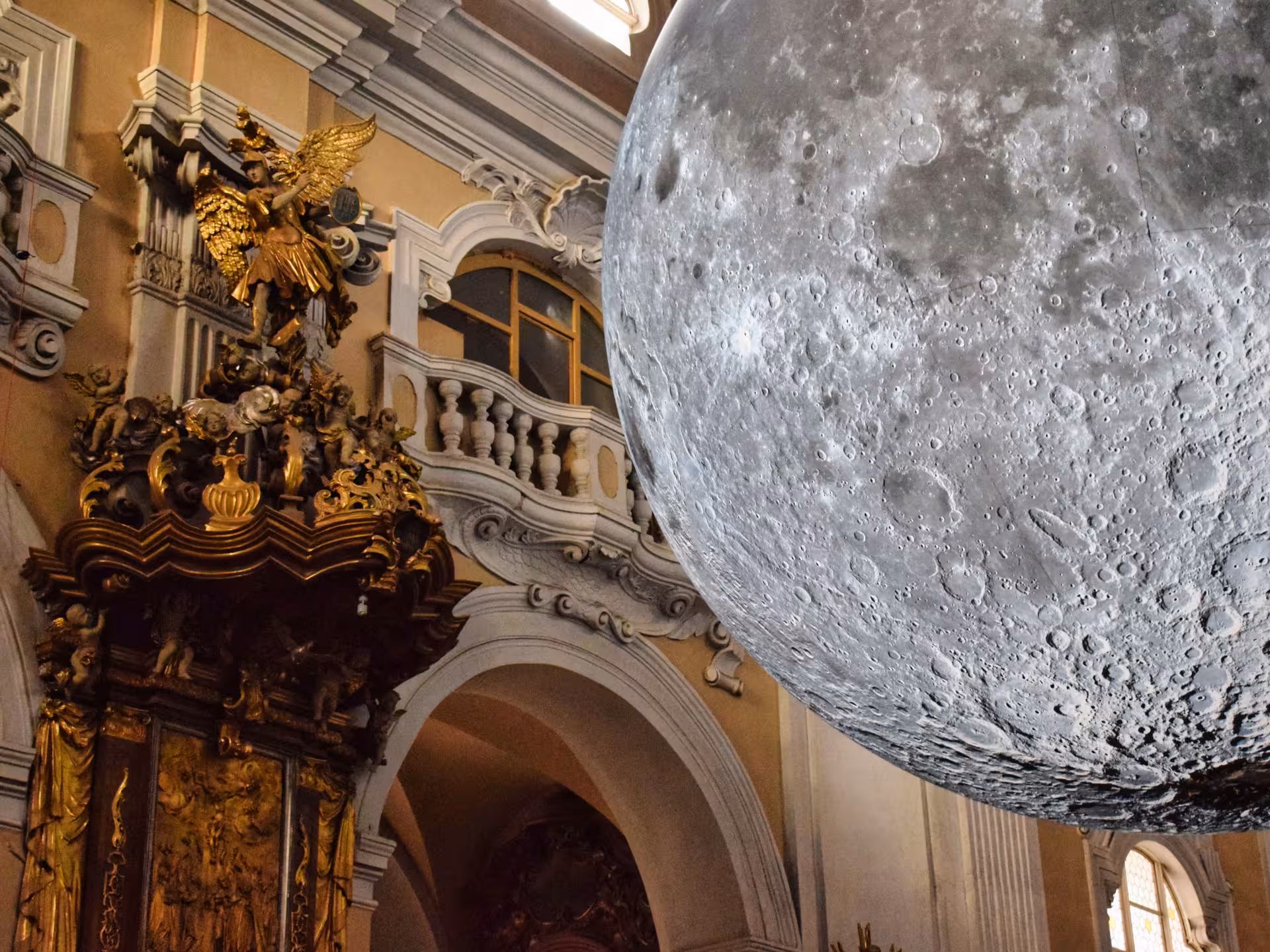 Hidden gem baroque church interior in Cluj featuring golden altar and stunning moon art installation