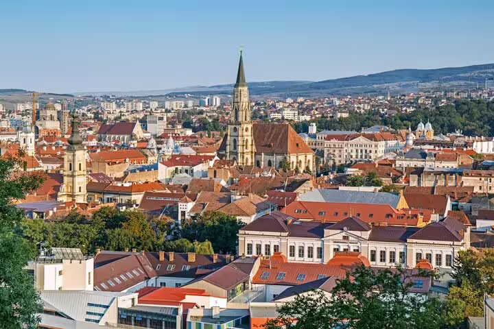 Aerial panoramic view of Cluj-Napoca old town with Gothic church spire and red-roofed buildings