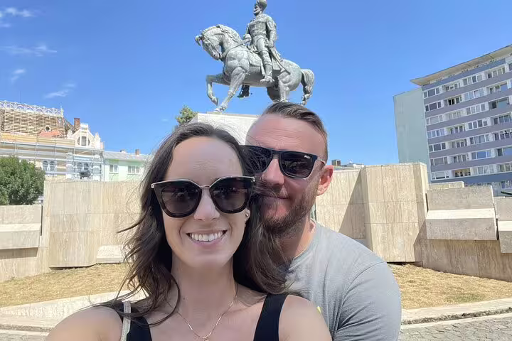 Couple taking a selfie in front of an equestrian statue in Cluj-Napoca city center