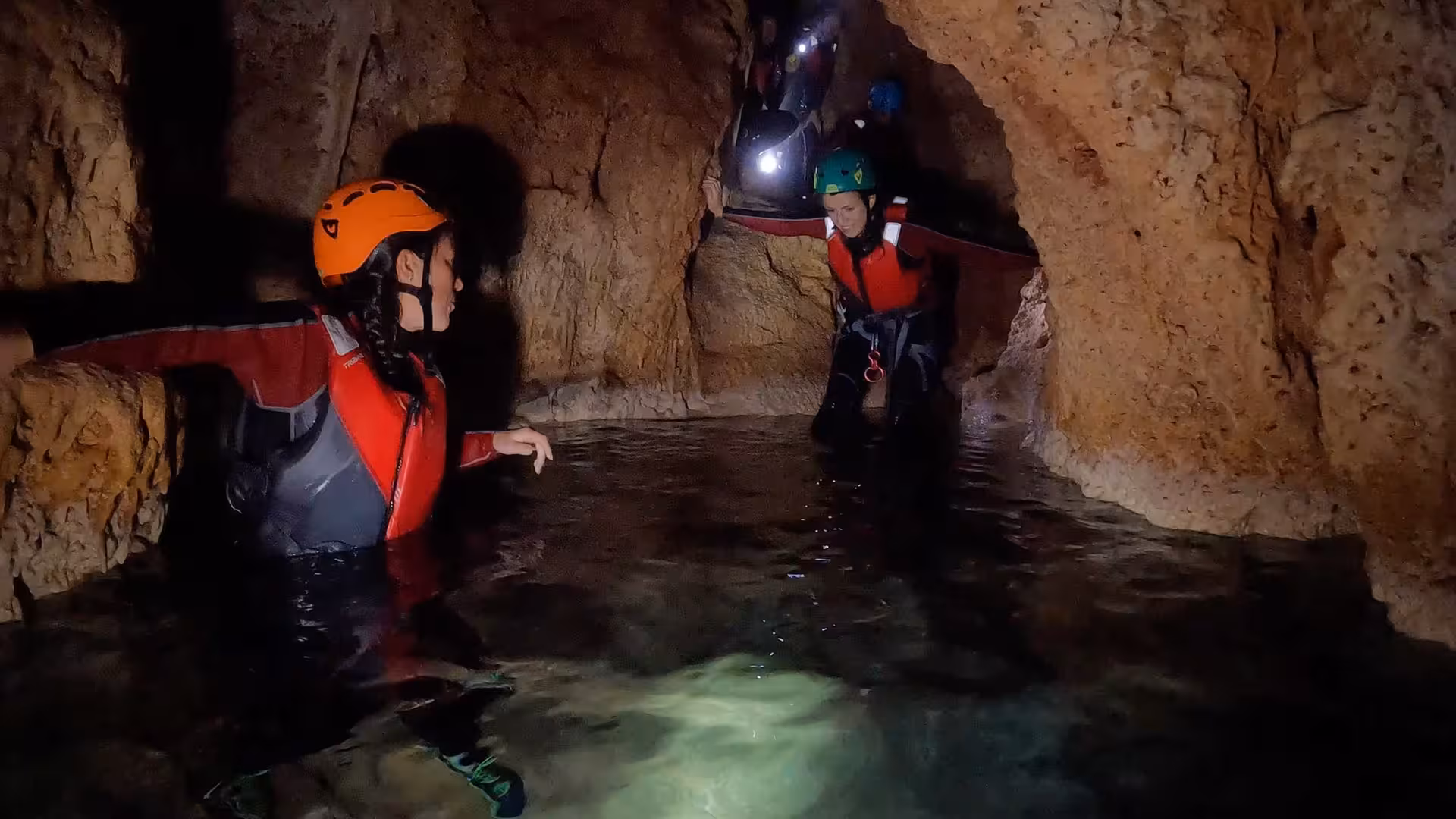Participants exploring a water-filled cave during coasteering adventure at Cala Dragunara, Porto Conte Park, Alghero.