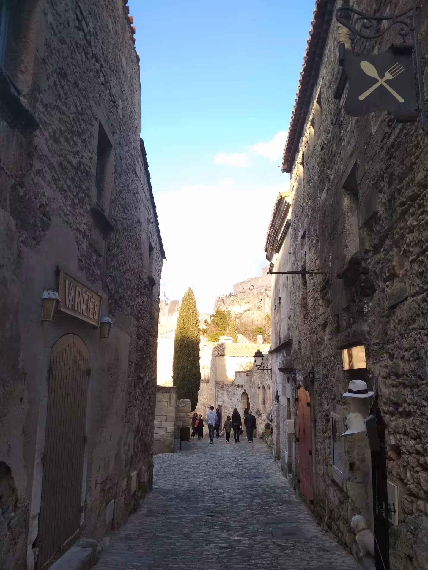 Cobblestone lane in Les Baux-de-Provence village with stone houses and views, Provence lifestyle day tour