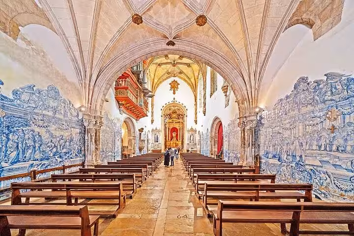 Stunning interior of Coimbra chapel adorned with intricate azulejo tiles and wooden pews, showcasing Portuguese heritage.