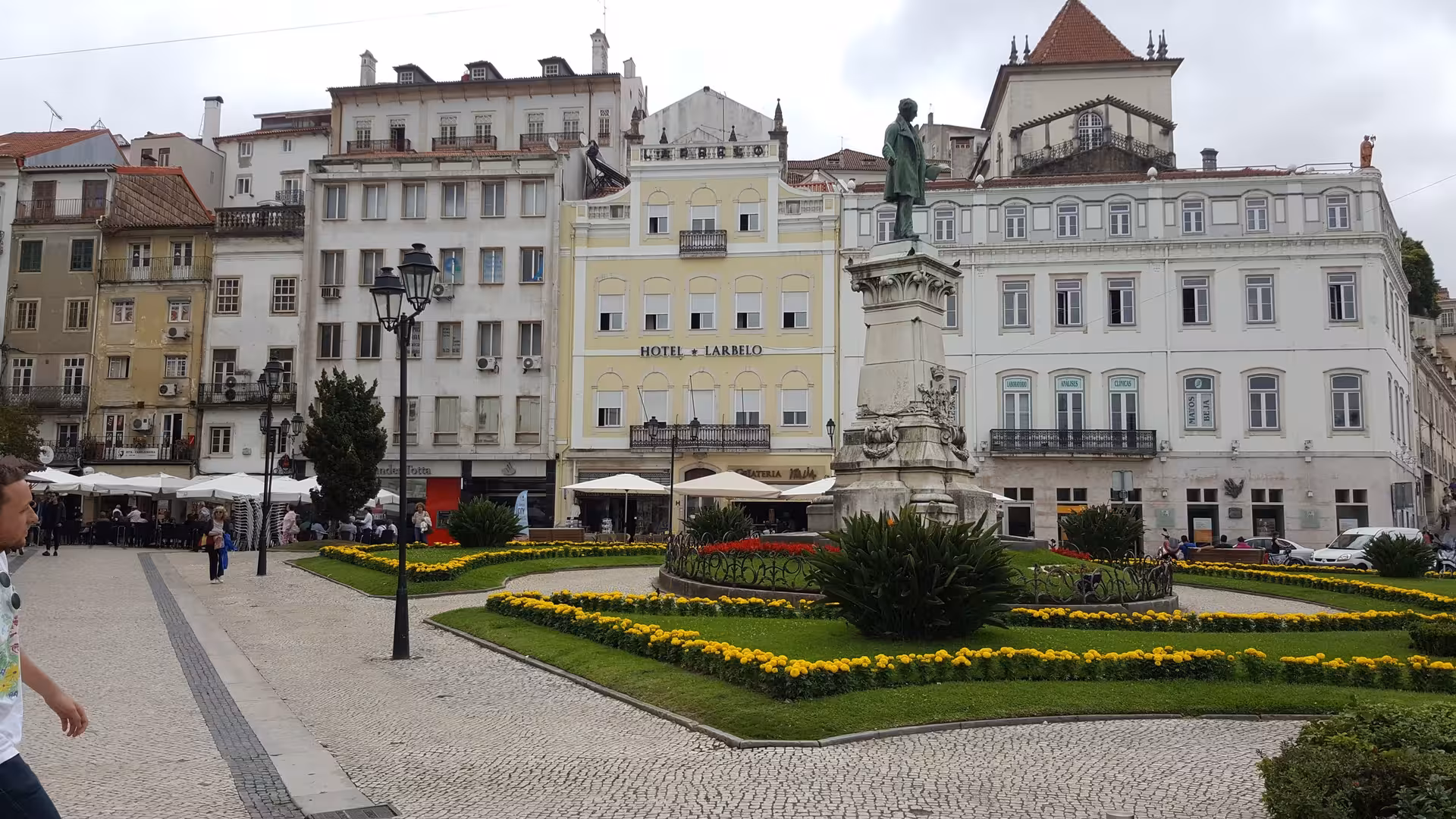 Coimbra city square with statue and cafés, a scenic stop on private Porto to Lisbon transfer tour