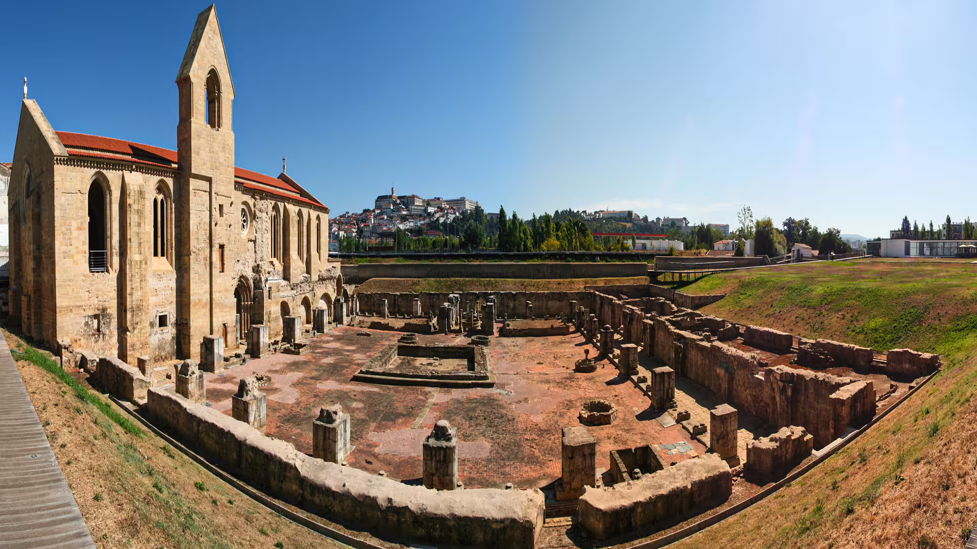 Ancient Roman ruins with a historic church in Coimbra, showcasing the blend of history on a private guided tour in Portugal.