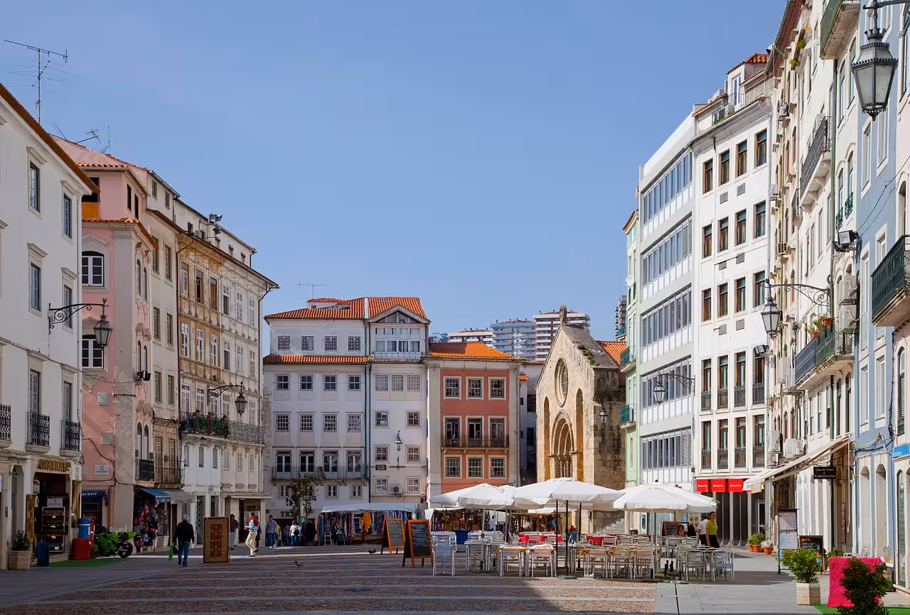 Coimbra historic center square with cafes and colorful buildings, stop on Porto to Lisbon private transfer tour