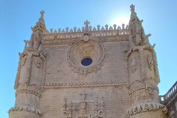 Ornate facade of a historic church in Coimbra with intricate stone carvings, included in the Tomar-Coimbra tour.
