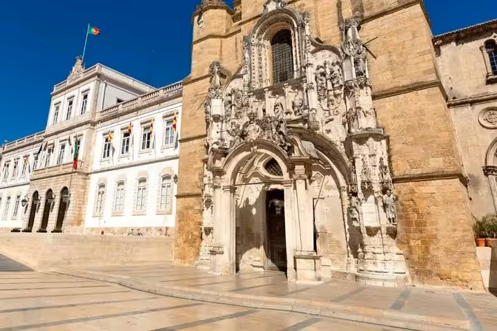 Stunning facade of a historical building in Coimbra, showcasing intricate architectural details on a sunny day.