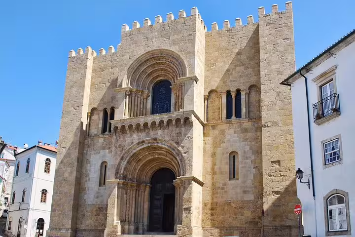 Historic Romanesque architecture of Coimbra's Old Cathedral on a sunny day, featured in the Fatima and Coimbra Private Tour.
