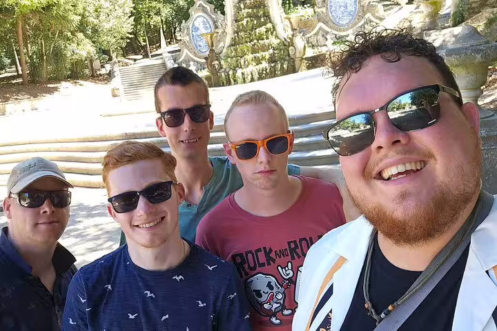 Friends pose at Coimbra’s Quinta das Lágrimas fountain stop on a self-guided scavenger hunt walking tour
