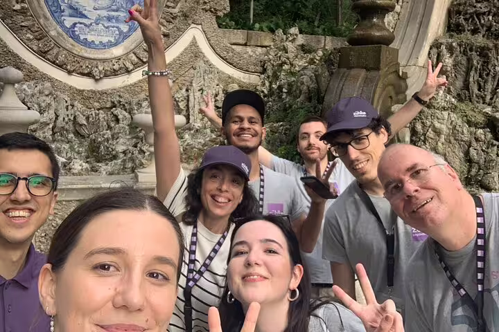 Smiling group selfie at Coimbra’s Quinta das Lágrimas azulejo fountain during a self-guided scavenger hunt tour